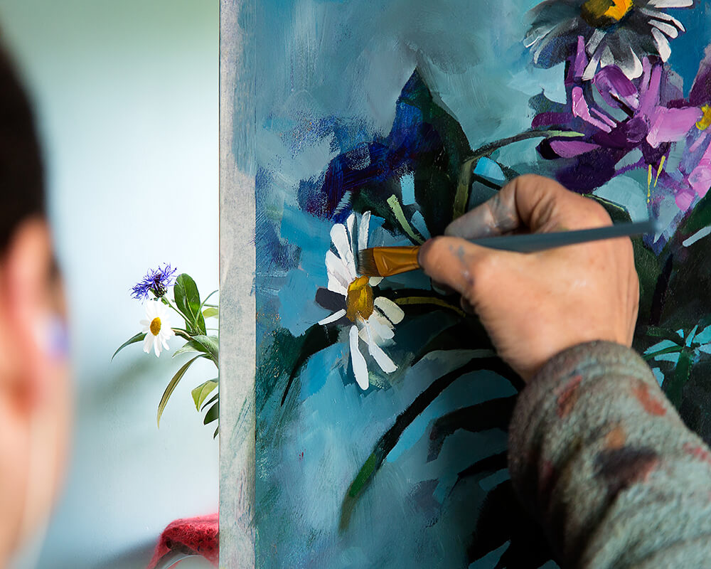 Aine Divine paints flowers in her workshop 