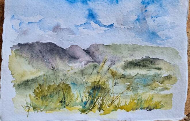A small watercolour landscape of hills and grasses on a sheet of handmade paper.