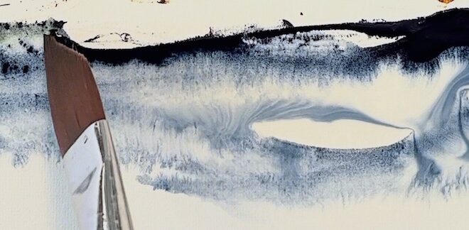 Indigo watercolour wash on white paper with the tip of the brush in view