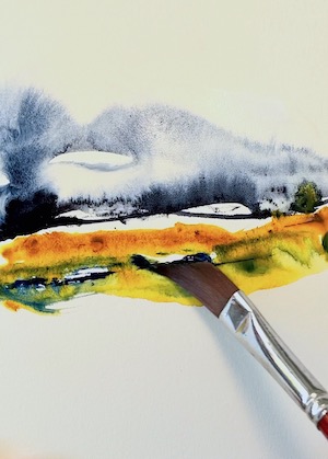A blue and gold watercolour work in progress with a painting brush tip